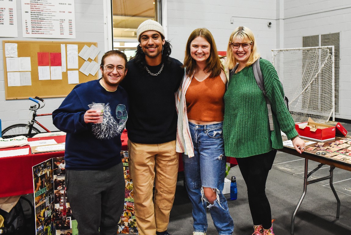 Four students stand smling at camera during Muhlenberg's Ecofest event.